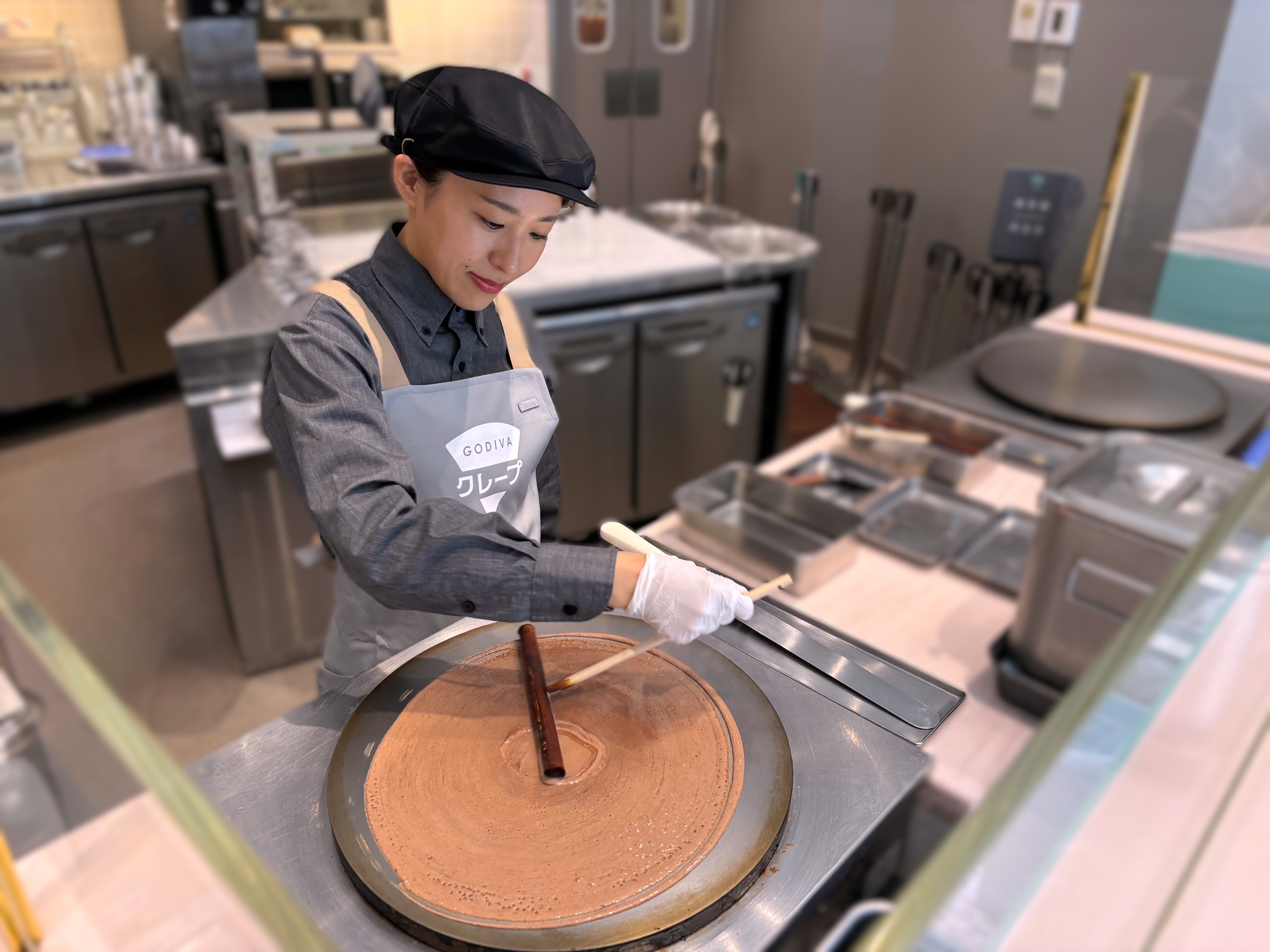 クレープを焼く女性店員