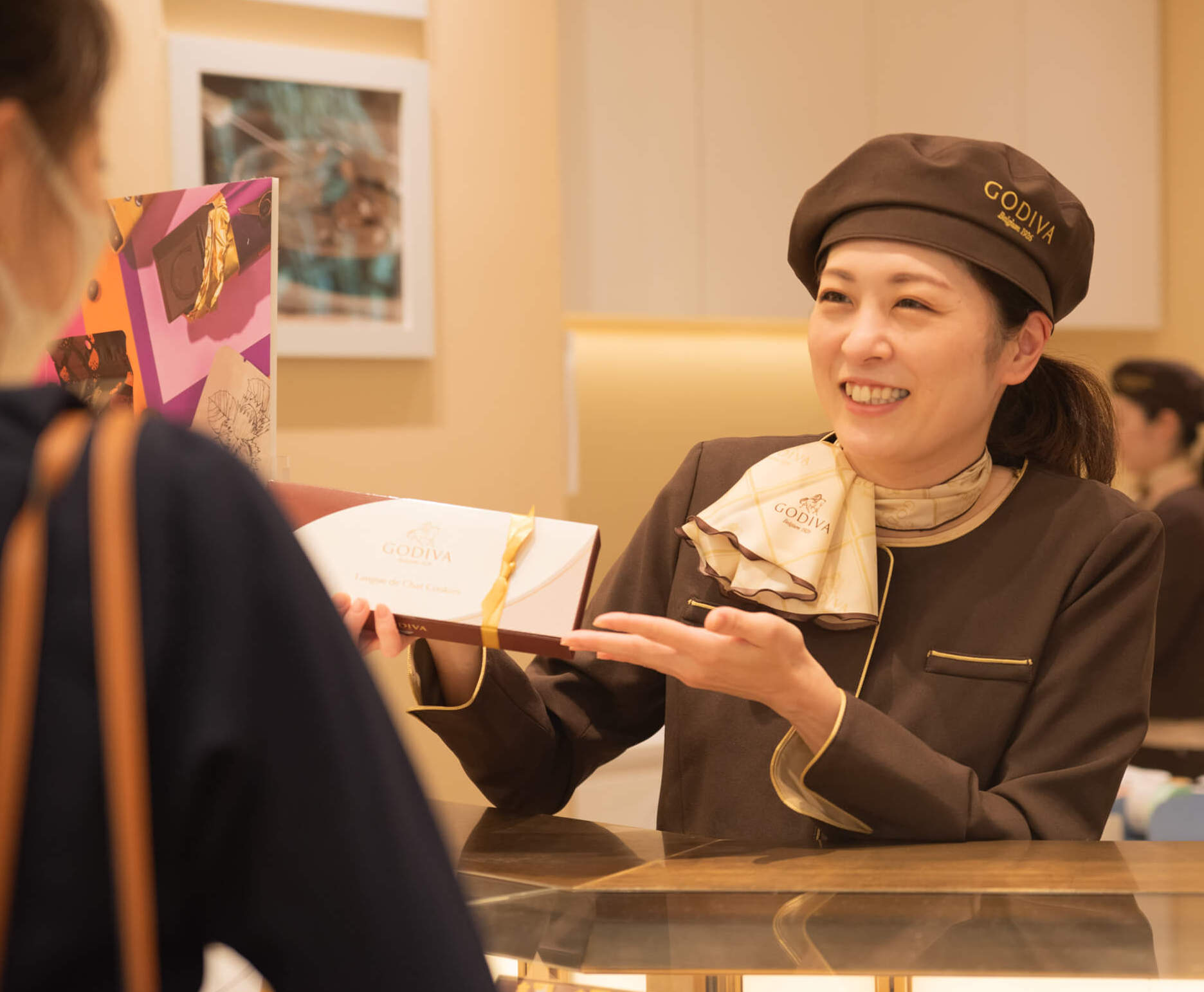 GODIVAの商品を案内する女性店員