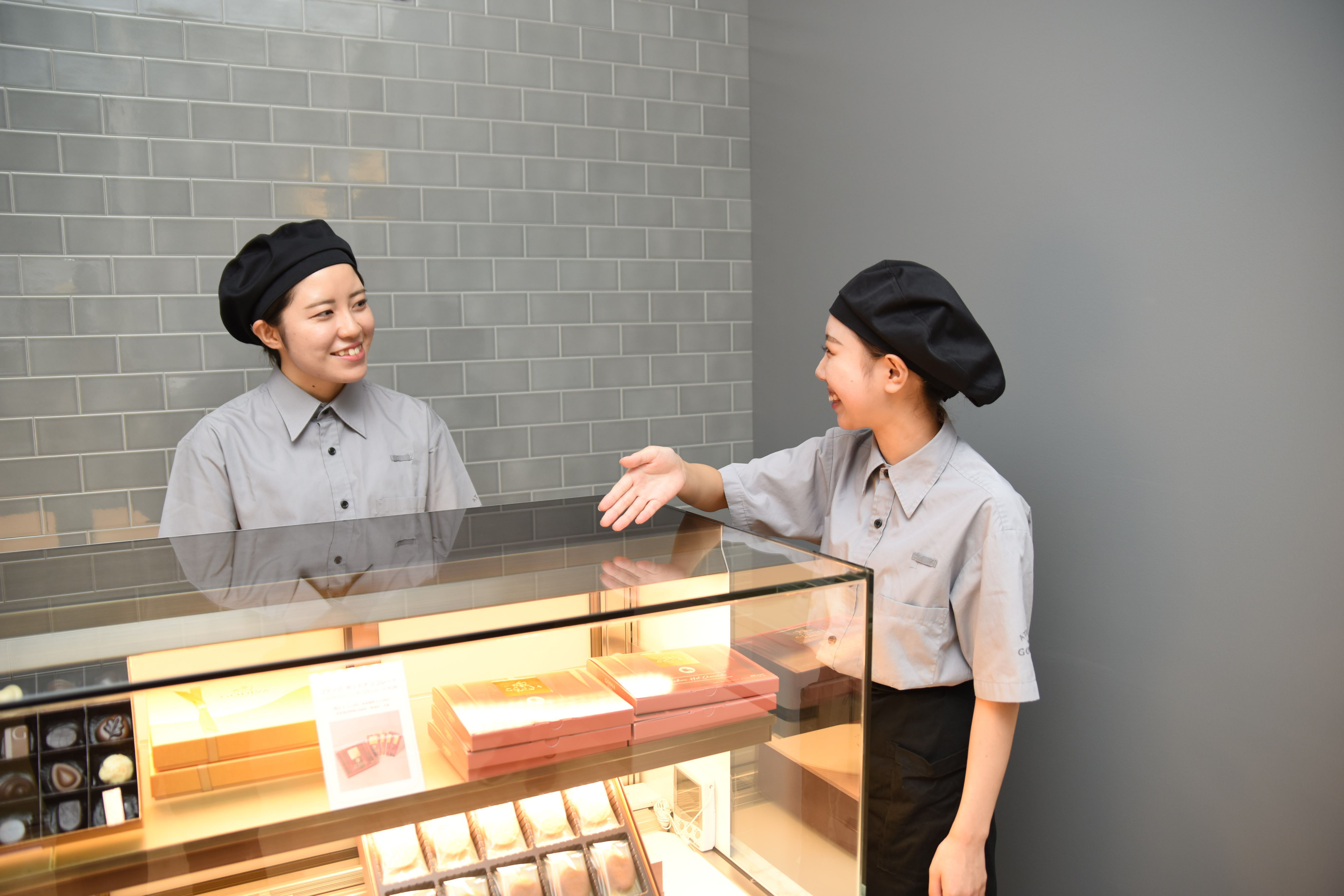 ゴディバの商品を案内する女性店員2名